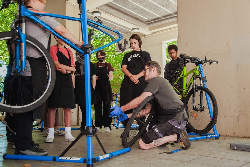 Man fixing bike as part of project